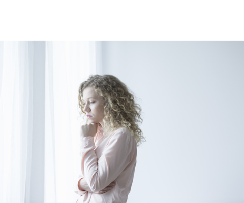 Afbeelding van een blonde vrouw die uit het raam kijkt