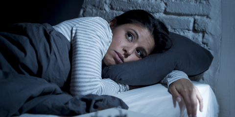 Afbeelding van een vrouw die in bed ligt met haar ogen open