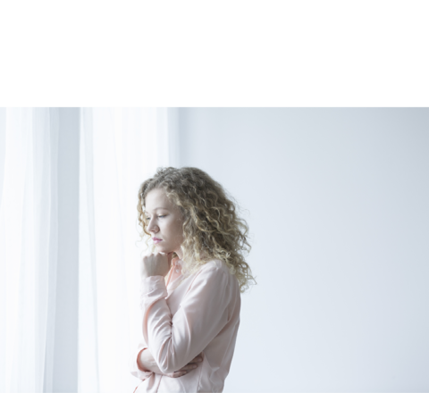 Afbeelding van een blonde vrouw die uit het raam kijkt